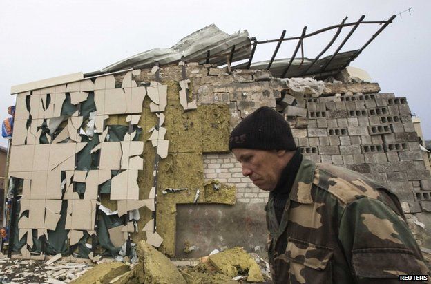 A man passes a cafe destroyed by shelling in Spartak, on the outskirts of Donetsk, 21 October