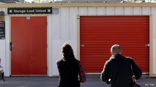 People stand outside a storage facility in Winnipeg, Manitoba, on 21 October 2014