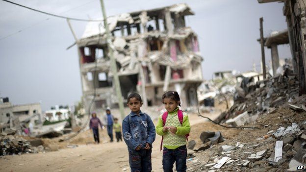 Palestinian school children walk through destroyed houses in Gaza City's Shejaiya neighbourhood. Photo: 19 October 2014