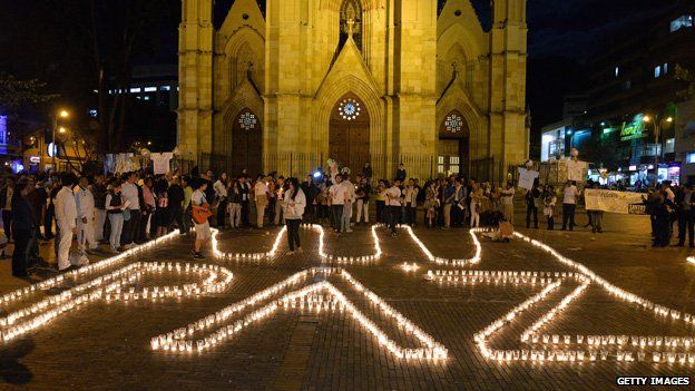 Supporters of the peace process with the Farc form the word "Peace" with candles on the floor during an event in Bogota on 11 June, 2014