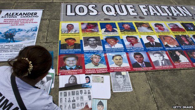 A woman arranges posters in support of victims of the Farc guerrillas on 4 August 4, 2014, in Cali