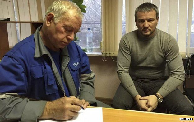 Vladimir Martynenko (L) signed his testimony beside his lawyer on Tuesday 22 Oct