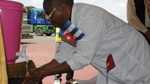 A Cuban health worker washes his hands upon arrival at Roberts Airport outside Monrovia in Liberia - 22 October 2014