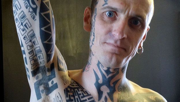 Man (Phil Cummins) showing swastika tattoo