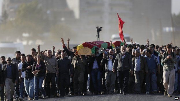 Mourners carry the coffins with of Kurdish fighters killed while fighting IS militants in Kobane