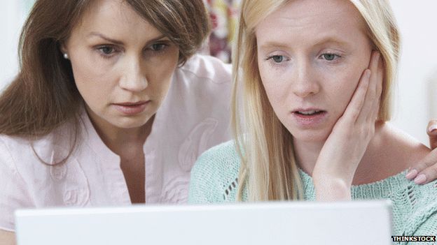 Girl and woman looking at computer