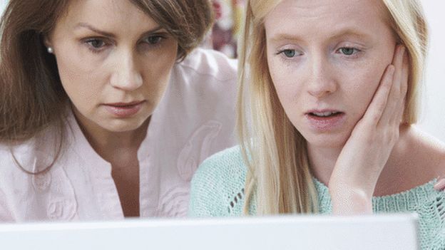 Girl and woman looking at computer