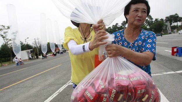 North Korean defectors carry to release a balloon to let it fly to the North, carrying chocolate pies and cookies during a rally against the North's recent threat at the Imjingak Pavilion near the border village of Panmunjom (DMZ) that separates the two Koreas since the Korean War, in Paju, South Korea, Wednesday, 30 July 2014.
