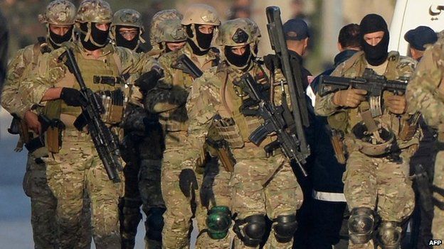 Members of the Tunisian military move to a position near a house in the town of Oued Ellil near the Tunisian capital Tunis, 24 October 2014