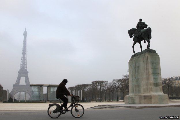 Bicyclist goes past Eiffel Tower in winter