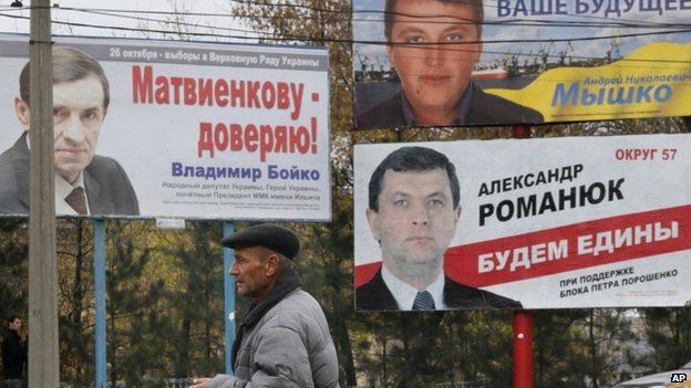 A man walks past election posters in Kiev, Ukraine on 23 October 2014