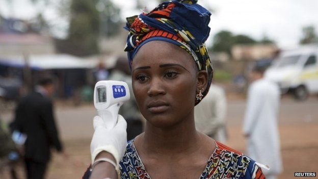 A woman's temperature is checked at the Guinea-Mali border, 2 October 2014