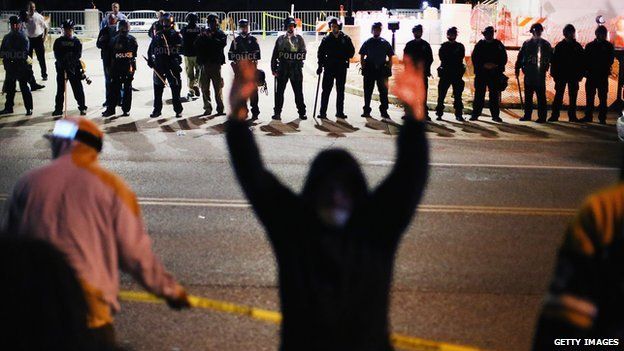 A protestor raises his hands in front of police during demonstrations in Ferguson, Missouri, on 22 October.
