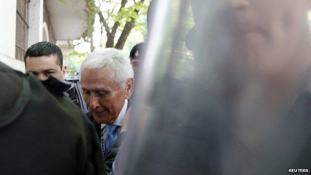 Miguel Etchecolatz (C), former Buenos Aires province's chief of police, is led into a courtroom to attend the final stage of his trial for his role in the kidnapping, murder and torture of people during Argentina's last dictatorship in La Plata on 24 October 2014.