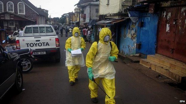 Health workers arrive to pick up the body of a young victim in Freetown, Sierra Leone, 24 Oct