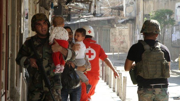 Soldiers help civilians evacuate as the Lebanese army clashes with Sunni militants, Tripoli, Lebanon, 25 October 2014.