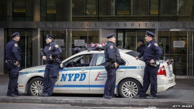 Police officers stand guard in front Bellevue Hospital where Dr Craig Spencer who was diagnosed with the Ebola disease remains in quarantine, on 25 October 2014 in New York City.