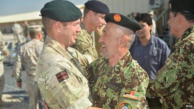 A UK soldiers hugs an Afghan soldier