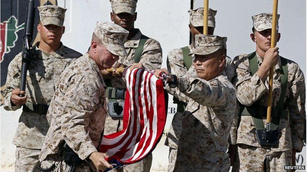 US military personnel taking down a US flag