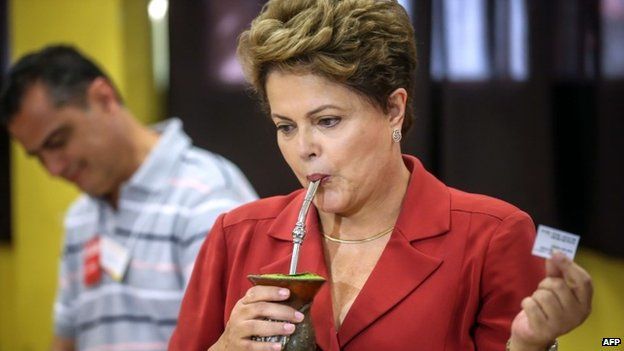 Brazilian President and presidential candidate for the Workers Party, Dilma Rousseff sips mate, a typical South American infusion, after voting at a polling station in Porto Alegre, state of Rio Grande do Sul, Brazil, on October 26, 2014