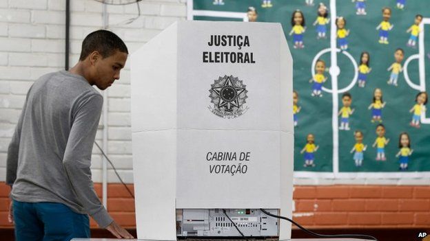 A boy arrives to vote on a voting machine during general elections in a school located at the Ceilandia neighborhood in Brasilia, Brazil, Sunday, Oct. 26, 2014