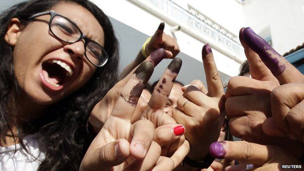 Tunisians show their ink-stained fingers after casting their votes, in Tunis October 26, 2014