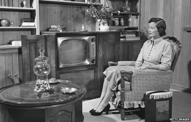 CIRCA 1950s - a black and white photograph of a woman watching television