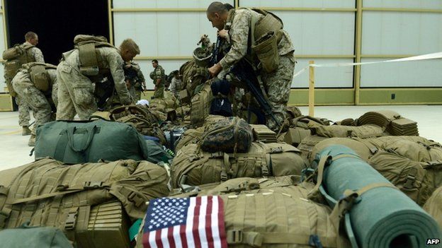 US Marines arrange their equipment as US troops arrive in Kandahar after their withdrawal from the Camp Bastion in Afghanistan on 26 October 2014