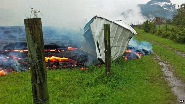 This Oct. 25, 2014 photo provided by the U.S. Geological Survey shows a small shed being consumed by lava in a pasture between the Pahoa cemetery and Apa?a Street near the town of Pahoa on the Big Island of Hawaii. Dozens of residents in this rural area of Hawaii were placed on alert as flowing lava continued to advance.
