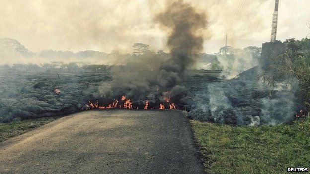 The lava flow from the Kilauea Volcano is seen crossing Apa'a Street/Cemetery Road in this U.S. Geological Survey (USGS) image taken near the village of Pahoa, Hawaii 25 October 2014