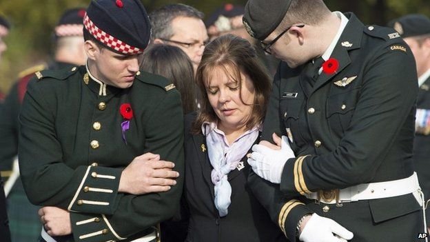 Кэти Чирилло утешают солдаты во время похоронной процессии ее сына капрал. Натан Чирилло в Гамильтоне, Онтарио, 28 октября 2014 г.
