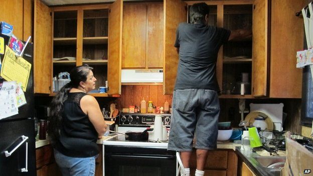 Denise Lagrimas, left, and her brother Beatle Rodriguez pack dishes at their home in Pahoa, Hawaii, on 28 October 2014