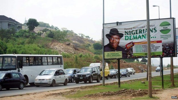 Cars pass an election poster of Nigerian President Goodluck Jonathan at a road in Abuja, Nigeria (27 October 2014)