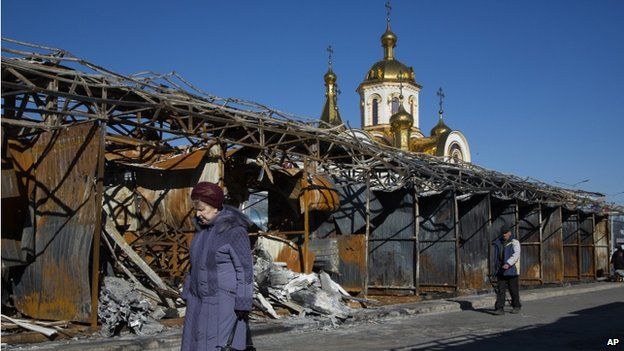 People walk past a bombed out street market near the train station in the town of Donetsk, eastern Ukraine