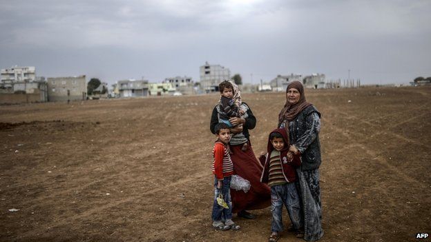 Kurdish refugees are pictured during a rainy day at the Rojova Camp, in Suruc, a rural district of Sanliurfa Province, on 30 October 2014.