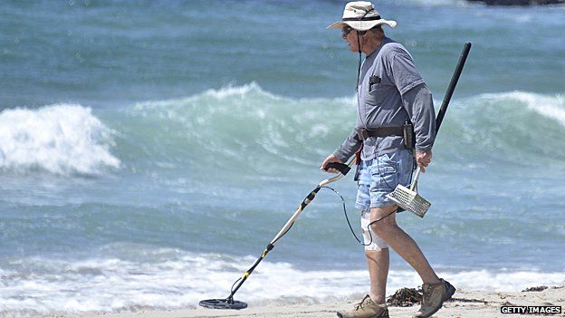 Man on beach with metal detector