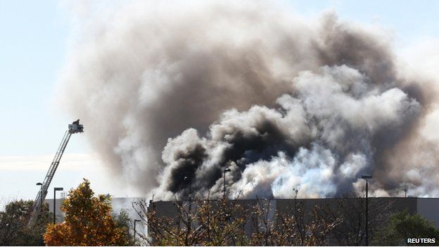 Smoke billows from a building at at Mid-Continent Airport shortly after a twin-turbo airplane crashed into a building in Wichita, Kansas, on 30 October 2014