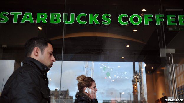 People walk past a branch of Starbucks in central London
