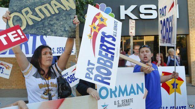 Supporters of independent senate candidate Greg Orman and Senator Pat Roberts rally outside of the KSN studios in Wichita, Kansas, on 15 October 2014