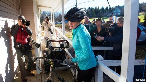 Kaci Hickox (centre) returns to her home surrounded by media after going for a bike ride with boyfriend Ted Wilbur in Fort Kent, Maine 30 October 2014