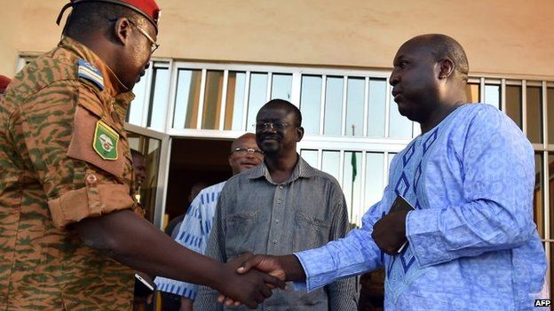 Burkinese Lieutenant-Colonel and interim leader Isaac Zida (L) escorts opposition leaders Zephirin Diabre (R), Benewende Sankara (C) and Roch Marc Christian Kabore (rear) at the end of a meeting between the army and opposition leaders in Ouagadougou, 2 November 2014