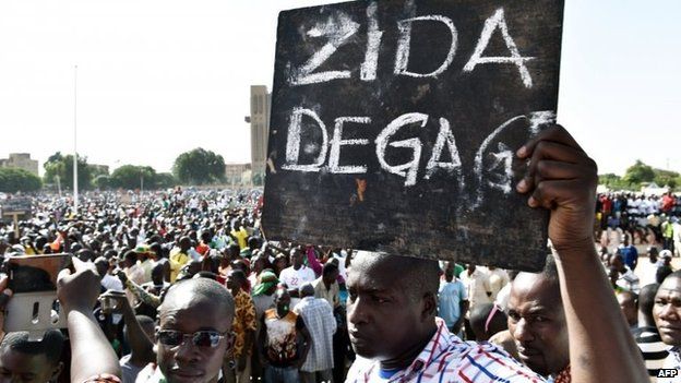 A man holds up a placard that reads in French, "Zida get out", referring to Isaac Zida, a high-ranking officer named by the military to lead the country's transition, during a protest at the Place de la Nation in Burkina Faso's capital Ouagadougou, 2 November 2014