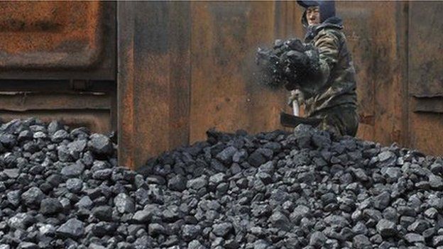 Worker unloading coal from railway in Shenyang, China, file photo from 2010