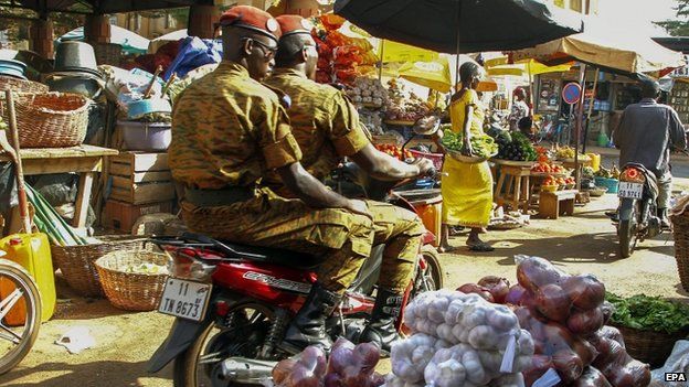 Soldiers ride a motorcycle through a market in Ouagadougou. Photo: 5 November 2014