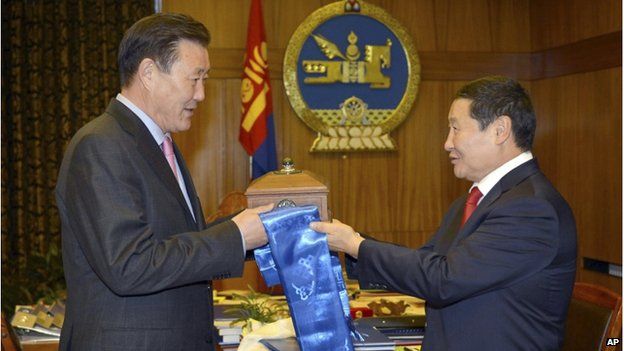 In this photo released by Press Service of the Government of Mongolia, Mongolian Prime Minister Norov Altankhuyag, right, hands over his official government seal to his senior deputy Dendev Terbishdagva who takes over as acting prime minister at the Mongolia government house in Ulan Bator, Mongolia Wednesday, 5 November 2014.