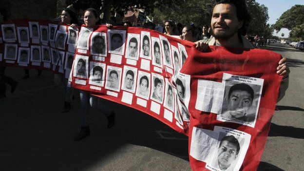 Students carry a banner with photographs of missing students. 5 Nov 2014