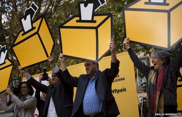 Oriol Junqueras, head of the pro-independence Republican Left of Catalonia, center, holds a drawing a of ballot box during a rally ahead of voting on an informal poll, scheduled for next Sunday, in Girona, Spain, on Saturday Nov.8, 2014