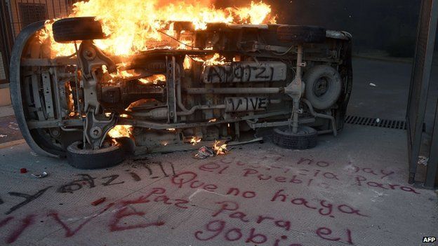 A burning car next to a graffiti outside the State Government headquarters in Chilpancingo, Guerrero State, on November 8, 2014.