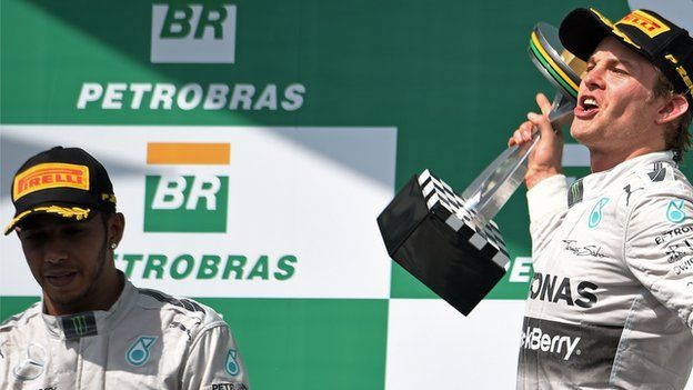 Nico Rosberg of Germany, right, and teammate Lewis Hamilton of Britain, stand on the podium for Formula One Brazilian Grand Prix