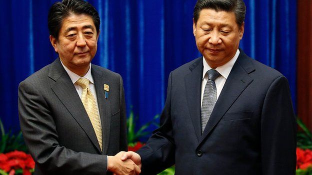 Japan's Prime Minister Shinzo Abe shakes hands with China's President Xi Jinping (R), during their meeting at the Great Hall of the People